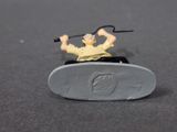 toy figurine of a man riding a skateboard on a gray surface