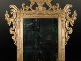 une image représentant un miroir à cadre doré accroché à un mur noir
