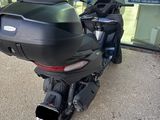 a black motorcycle parked outside of a building on the sidewalk