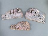 trois morceaux de roche percés de trous, posés sur une table