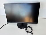 a close up of a computer monitor on a desk with a charger