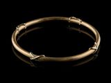 a close up of a gold bracelet on a black background