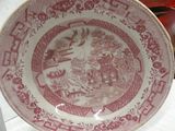 a red and white plate with a bird on it