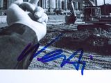 signed photograph of a man pointing at a construction site with a bulldozer in the background