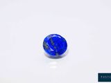une bille bleue et noire sur une surface blanche