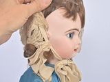 a doll that is wearing a bonnet and a blue shirt