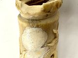 a stone vase with a bird on it sitting on a table