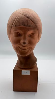 a clay sculpture of a woman ' s head on a wooden stand