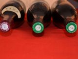 three bottles of wine sitting on a red table