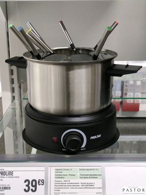Des casseroles et des poêles sont exposées dans un magasin, accompagnées d'étiquettes de prix
