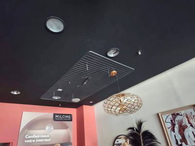 une femme qui se tient debout dans une pièce où il y a une horloge au plafond
