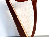 a large wooden harp sitting on the floor next to a white wall