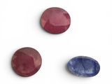 three different colored gems on a white surface
