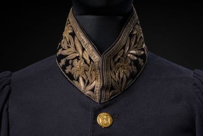 un gros plan sur un mannequin portant une veste noire et dorée