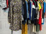beaucoup de vêtements suspendus à une étagère dans une pièce