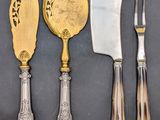 three silver and gold plated knives, a knife, and a spoon