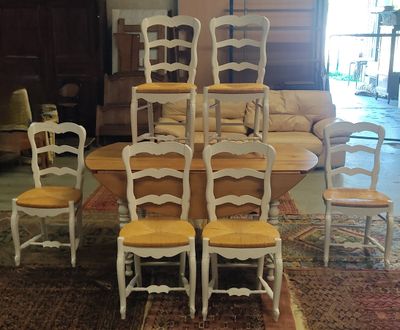 Plusieurs chaises sont empilées les unes sur les autres dans une pièce.