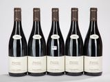 six bouteilles de vin sont alignées sur une table