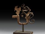 une sculpture en bronze représentant un oiseau et une fleur, posée sur un socle