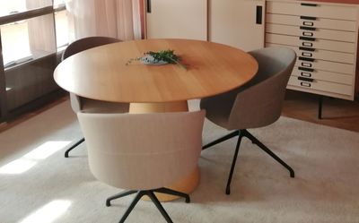 a table with two chairs and a vase on it