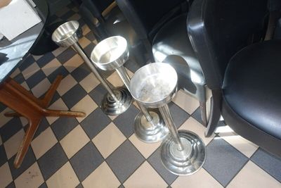 deux vases en argent posés sur le sol à carreaux d'un restaurant