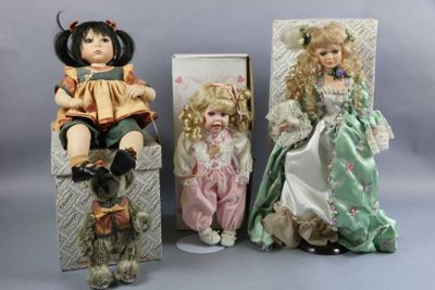 three dolls sitting next to each other on a table