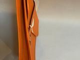 an orange purse sitting on top of a white table