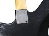 the back of a black electric guitar with a wooden neck