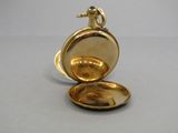 a small gold pocket watch sitting on a table