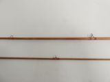 two old fishing rods hanging on a wall next to each other