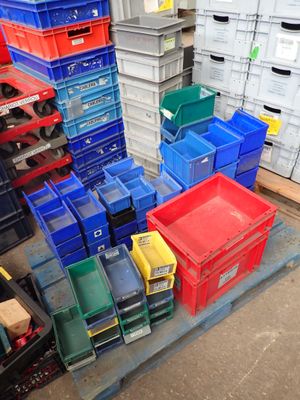 de nombreux conteneurs en plastique empilés sur une palette dans un entrepôt