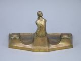 brass statue of a woman sitting on a boat with a man on it