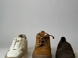 three pairs of shoes are lined up in a row on a white surface