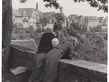 photographie en noir et blanc de deux femmes penchées au-dessus d'un mur de pierre