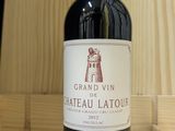 a bottle of red wine sitting on a wooden table