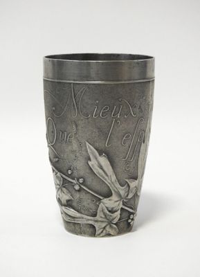 une coupe en argent ornée d'un dragon sur un fond blanc