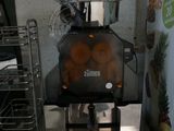 an image of a juicer with oranges inside of it