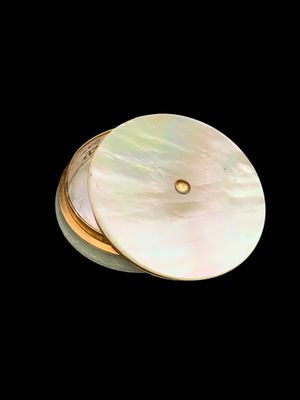 deux morceaux de coquillage blanc bordés d'or sur fond noir
