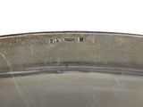 a metal bowl with a handle on a white surface