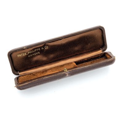 a brown case with a pen in it on a white surface