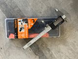 a caliper that is laying on the ground next to a box