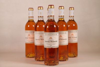 six bouteilles de vin sont alignées sur une surface blanche