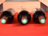 three bottles of wine sitting on a red table