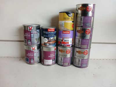 many cans of paint sitting on a counter next to each other