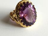 a close up of a ring with a purple stone in it