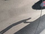 a reflection of a person on the side of a car