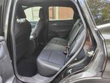 the back seats of a car with the door open and the driver ' s seat down