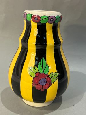un vase jaune et noir orné de fleurs peintes