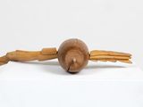 a wooden sculpture of a bird with wings on top of a white box