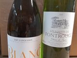two bottles of wine sitting next to each other on a table
